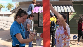 Two ASU students paint during a day of service