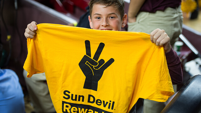 kid holding Sun Devil Rewards shirt