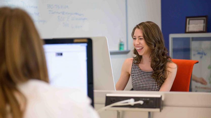 Student smiling while working on computer